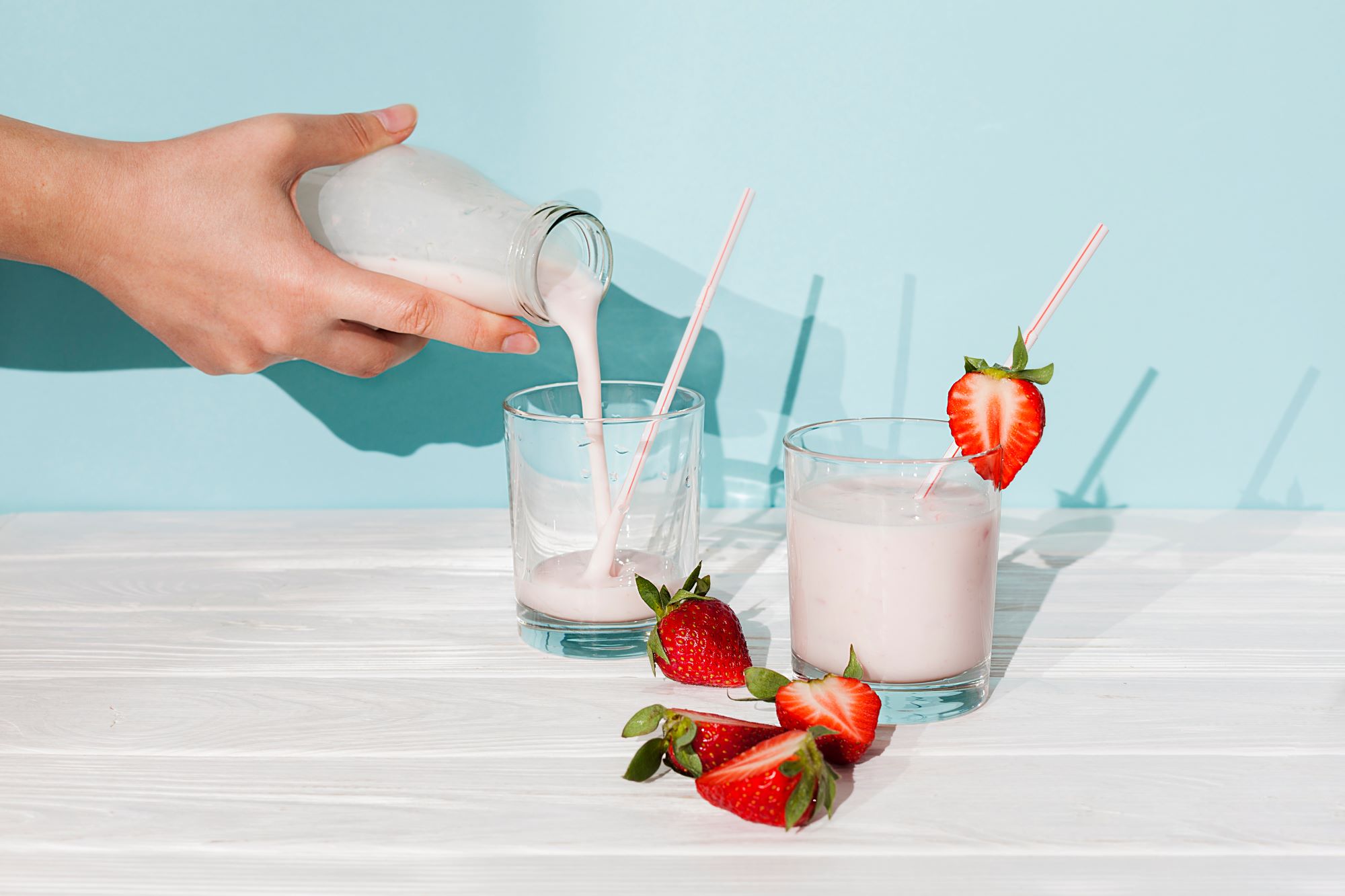 Pouring yogurt drink into glass containing high fibre and prebiotics for better-for-you food products